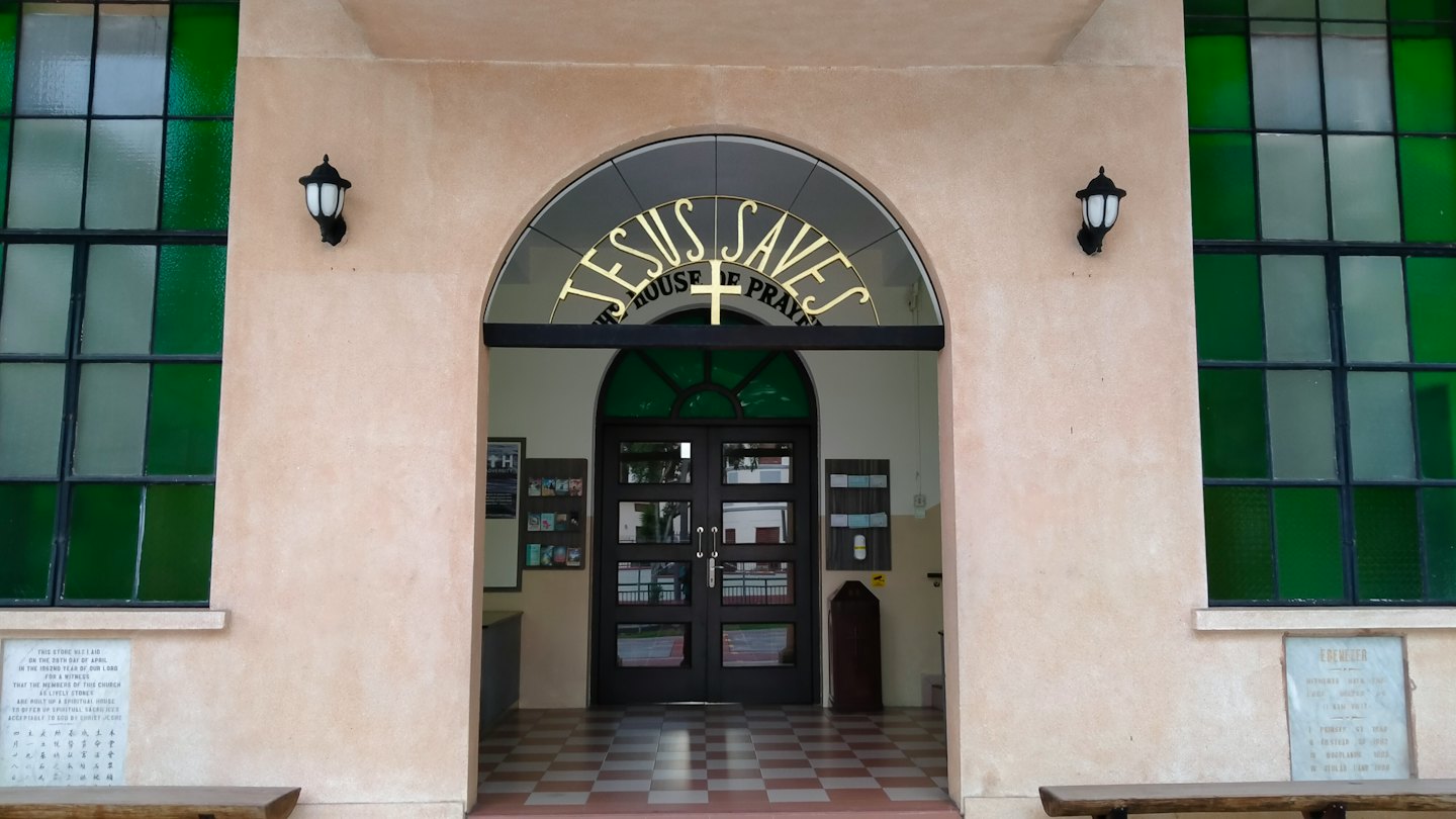 Double doors at a church entrance with arched gold lettering.